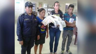 Una agente de la DNIC sostiene a la niña que había sido robada a la pareja en Tegucigalpa.