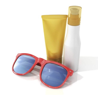 Bottles of suntan cream with sunglasses isolated on white.
