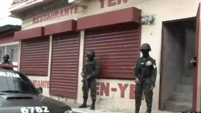 Elementos de la Policía Militar resguardan el restaurante allanado.