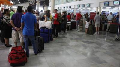Un grupo de viajeros en la terminal del aeropuerto de San Pedro Sula.