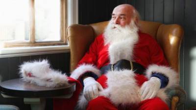 A Santa Claus figurine on a toy bike drives on a tightrope spanning over the Christmas market in Osnabrueck, northwestern Germany, on December 19, 2019. (Photo by Friso Gentsch / dpa / AFP) / Germany OUT