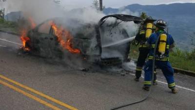Bomberos cuando intentaban apagar las llamas que consumieron el vehículo.