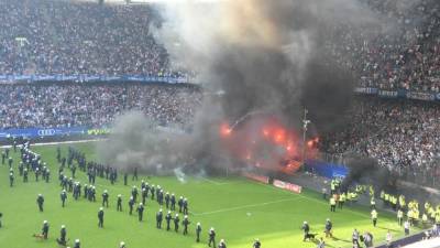 La policía tuvo que ingresar al campo a parar los ataques de los aficionados del Hamburgo. FOTO EFE David Hecker.
