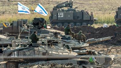 Soldados israelíes y vehículos blindados se reúnen en un lugar no revelado cerca de la frontera con Gaza, en Israel.