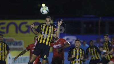 Devron García, defensa del Real España, despejando la pelota en el área.