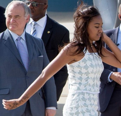 US President Barack Obama (R) and daughter Malia make their way across the South Lawn upon return to the White House on January 4, 2015 in Washington, DC. Obama and his family returned to Washington after spending the holidays in Hawaii. AFP PHOTO/Mandel NGAN (Photo credit should read MANDEL NGAN/AFP/Getty Images)