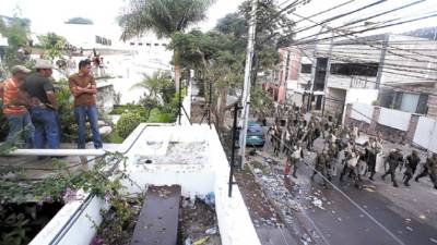 A supporter of Honduras' ousted President Manuel Zelaya looks at soldiers walking in front of the Brazilian embassy in Tegucigalpa, after Zelaya supporters clashed with riot police Tuesday, Sept 22, 2009. Baton-wielding police fired tear gas at thousands of demonstrators Tuesday morning, chasing them away from the Brazilian embassy where their deposed president who snuck back into the country remains holed up, avoiding threatened arrest. (AP Photo/Esteban Felix)