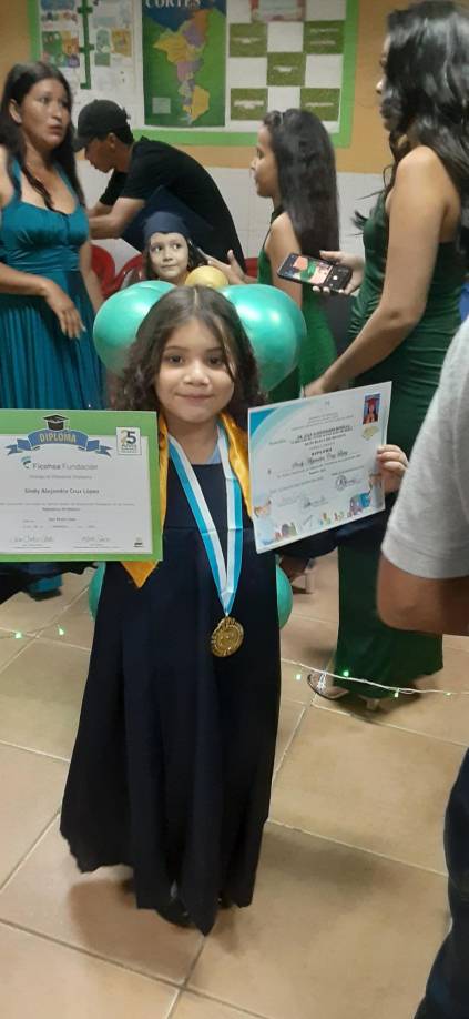 La alumna Sindy Alejandra Cruz López posa junto a sus dos diplomas obtenidos en esta jornada de clausura educativa.