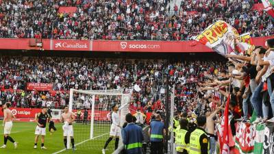 Los jugadores del Sevilla celebran con los aficionados sevillistas su triunfo ante el Betis al final del encuentro correspondiente a la jornada 26 de primera división disputado en el estadio Ramón Sánchez Pizjúan de Sevilla.
