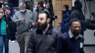 Personas con máscaras caminan por una acera en Nueva York.