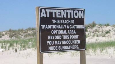 Rótulo que advierte de una playa nudista.