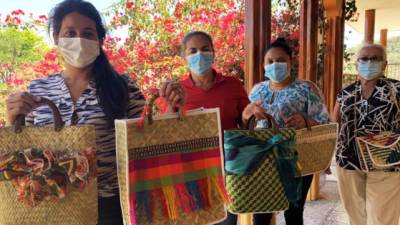 Las emprendedoras hondureñas posan con las carteras artesanales.