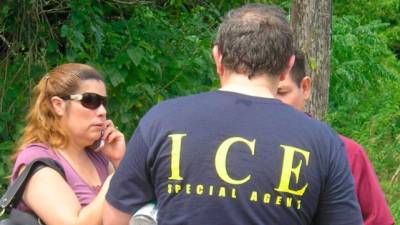 Un agente del Servicio de Inmigración y Aduanas (ICE) conversa con los familiares de algunos de los inmigrantes indocumentados que fueron detenidos en Houston.