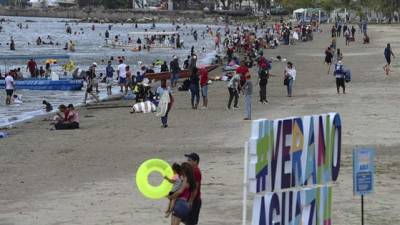 Hondureños disfrutan de un día de playa durante la Semana Santa a pesar de la pandemia del nuevo coronavirus, en la ciudad caribeña de Puerto Cortés. (FOTOS AFP)