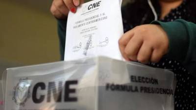 Hondureño introduce su voto en una urna del CNE.