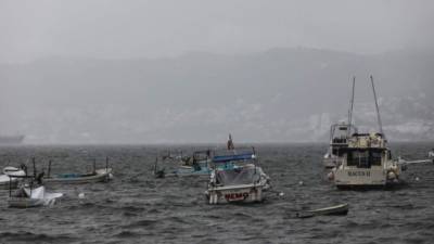 Pescadores resguardan sus embarcaciones este viernes, en el malecón de Acapulco.