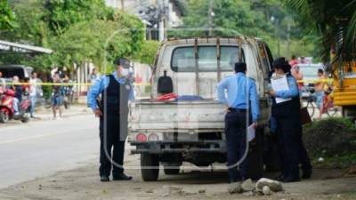 Policías inspeccionan el vehículo en el que dejaron los cuerpos de tres hombres en El Limonar.