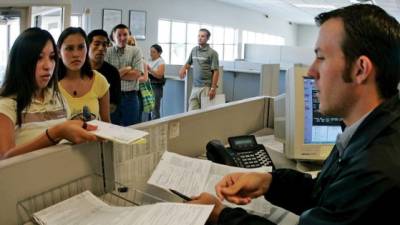 La joven mexicana Sherrell Jeli (izda) entrega los papeles para solicitar su carnet de conducir.