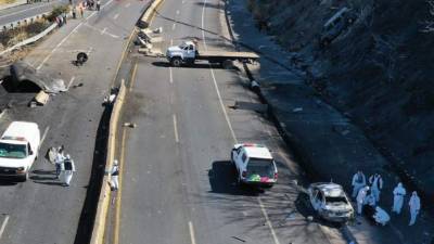 Peritos forenses realizan el levantamiento de cuerpos en el sitio en que explotó un camión cisterna.