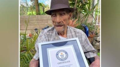 Emilio Flores mientras sostiene el certificado que le acredita como el hombre más longevo del mundo.