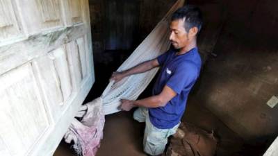 Marvin Contreras es un campesino que rescata algunas pertenecías mientras limpia su casa de lodo a causado por las tormentas tropicales Eta y Iota en la comunidad de Omonita en el norte de Honduras.