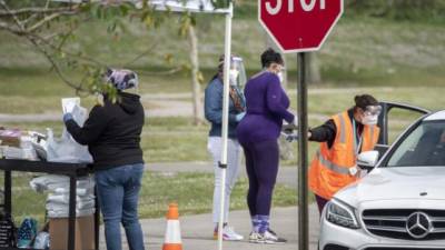 Trabajadores de la salud orientan a las personas que recibirán la vacuna Pfizer-BioNTech COVID-19 en Vista View Park en Davie, Florida, EEUU.