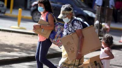 Dos niñas caminan junto a un familiar hoy en Tegucigalpa (Honduras).