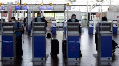 Unos viajeros hacen su check-in en el Aeropuerto Internacional Arturo Merino Benítez, en Santiago, Chile. (EFE)