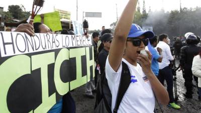 Una hondureña al frente de una pancarta alusiva a la Cicih.