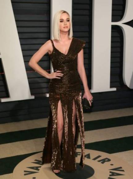 La cantante Katy Perry dejó ver sus piernas con este vestido dorado y entallado.