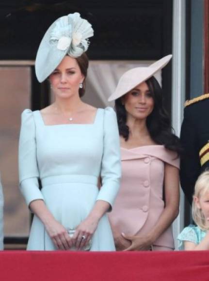 Meghan lució un conjunto de falda y chaqueta rosa con escote de Carolina Herrera que contrastaba con el elegante y discreto atuendo de su cuñada, Kate Middleton.<br/>