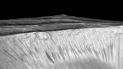 Las venas oscuras que emanan del cráter 'Garni' en Marte se creen que fueron hechas por corrientes de agua líquida.