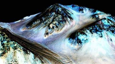 Fotografía facilitada por la Agencia Espacial de Estados Unidos (NASA) que muestra cauces conocidos como surcos lineales (RSL), supuestamente formados por agua líquida en Marte. EFE