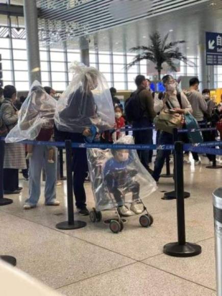 Desesperados pasajeros chinos usan botellas y bolsas para 'protegerse' del coronavirus