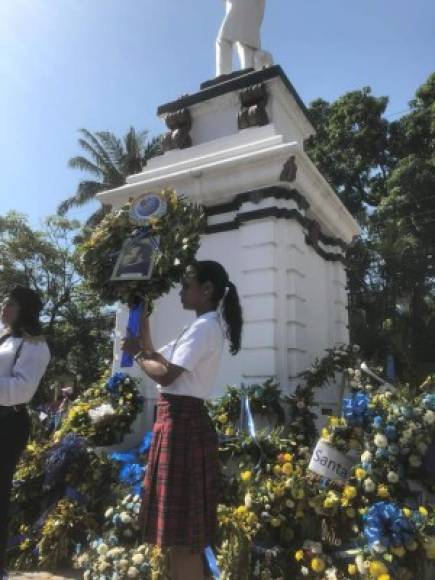 Stefanie Guzmán de la Escuela Iberoamericana coloca la ofrenda floral en la estatua de Francisco Morazán.