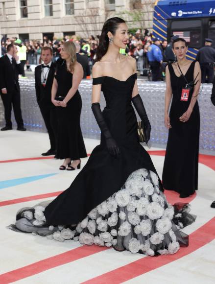 La supermodelo China Liu Wen con un vestido con corte de sirena con abertura para poder ver las camelias.