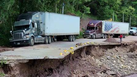 Después de varias horas sin acceso, las pesadas rastras que trasladan materia prima entre Honduras y Guatemala lograron pasar por una estrecha vía que se habilitó.