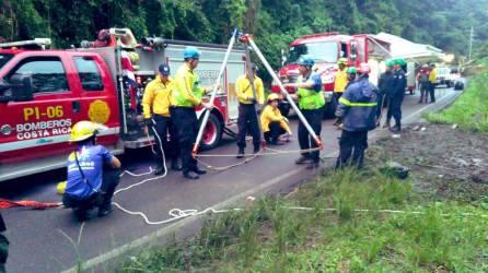 Los bomberos, agentes de la Fuerza Pública y la Cruz Roja siguen las labores de rescate tras el accidente de un autobús por las fuertes lluvias en Costa Rica.