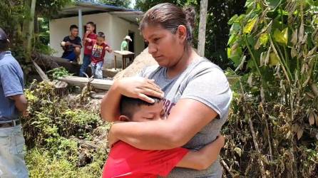 María Beatriz Gómez consuela a uno de sus hijos luego que su exmarido les quemara la casa en una comunidad de Florida, Copán.