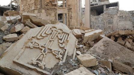 Un trozo de piedra con una cruz tallada yace sobre una montaña de escombros en la ciudad de Deir al Zur, en el este de Siria.