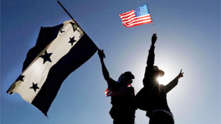 Una fotografía ilustrativa de hondureños con banderas del país y de Estados Unidos.