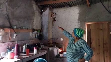 La señora María del Carmen Ulloa, de la aldea Joyas de Mula de Las Lajas, Comayagua, muestra cómo la pared de su cocina se despegó de la columna por donde pasa el escape de la hornilla a causa de los sismos.