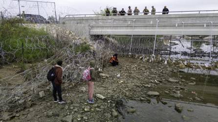 Soldados de la Guardia Nacional de Texas vigilan a un grupo de migrantes que intenta ingresar a ese estado.