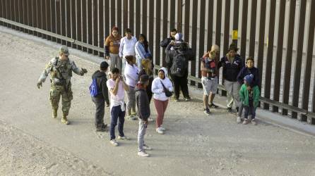 Un grupo de migrantes es vigilado por la Guardia Nacional tras ingresar a Texas.