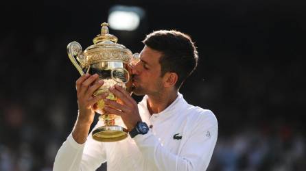Novak Djokovic besando el título que lo acredita nuevamente como el rey de Wimbledon.
