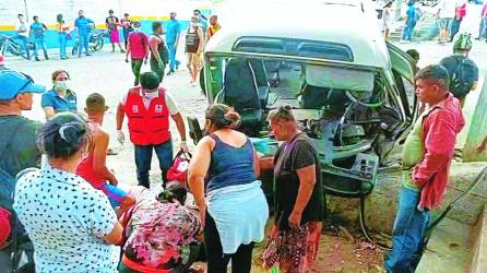 Paramédicos de Cruz Roja y curiosos auxilian a los lesionados que dejó el accidente ayer en el bulevar entre San Pedro Sula y Choloma.