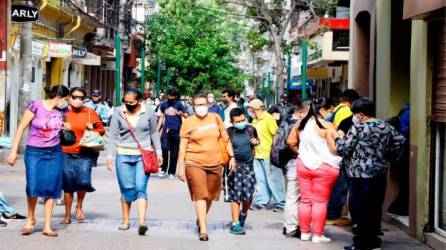 Personas siendo captadas este martes al caminar por el casco histórico de Tegucigalpa. Foto EFE