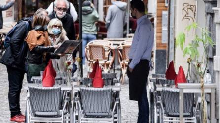 Un camarero espera a los clientes en una terraza en Bruselas mientras el gobierno de Bélgica alivió las restricciones impuestas. Foto AFP