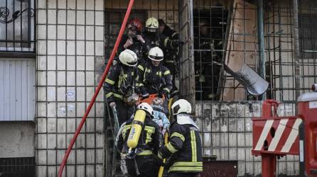 Los bomberos sacan el cuerpo de una mujer de un edificio de apartamentos destruido en Kiev.