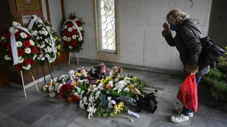 Una mujer presenta sus respetos en un memorial improvisado para las víctimas en la embajada de Macedonia del Norte en Sofía, un día después de que un autobús turístico se incendiara y se estrellara.